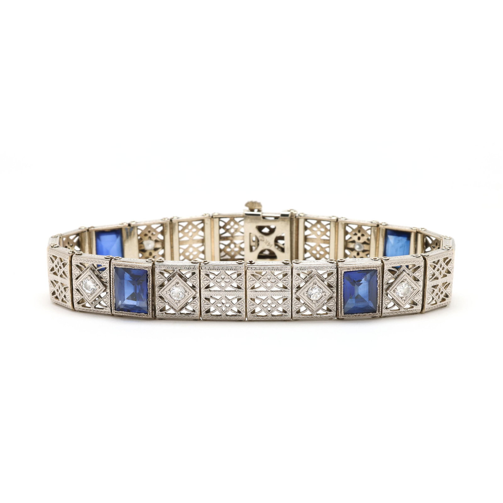Vintage White Gold, Diamond, and Synthetic Sapphire Bracelet: Vintage White Gold, Diamond, and Synthetic Sapphire Bracelet the bracelet comprised of filigree links set with transitional cut diamond melee and with rectangular cut synthetic sapphires, the edge