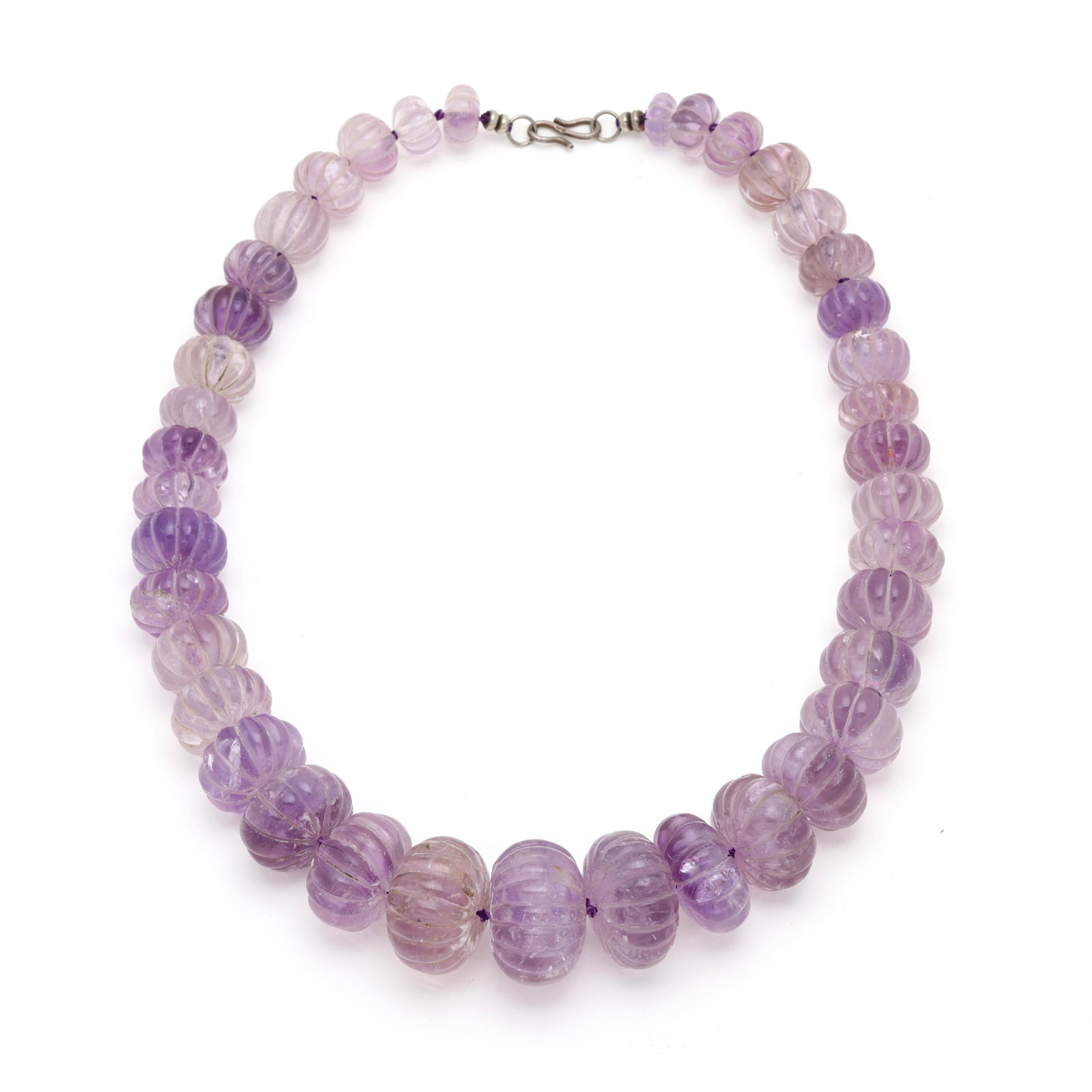 Carved Amethyst Bead Necklace: Carved Amethyst Bead Necklace strung knotted with graduated carved amethyst beads (13mm to 32mm), completed with a hook clasp testing silver. 24 in. Additional high-resolution photos are available at