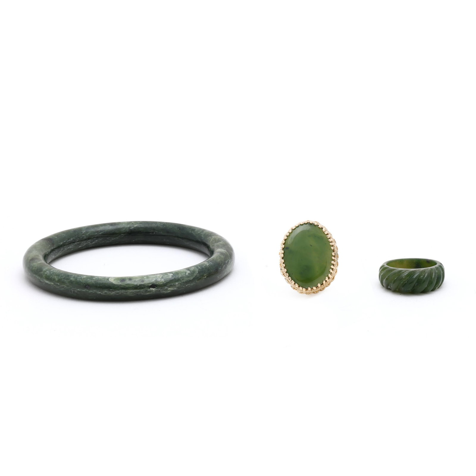 Group of Nephrite Jade Jewelry: Group of Nephrite Jade Jewelry to include: a nephrite jade bangle carved in the round (9mm; 2 3/8 in. interior diameter); a nephrite jade ring carved in rope motif (8.5mm; ring size 7.75); and a gold 