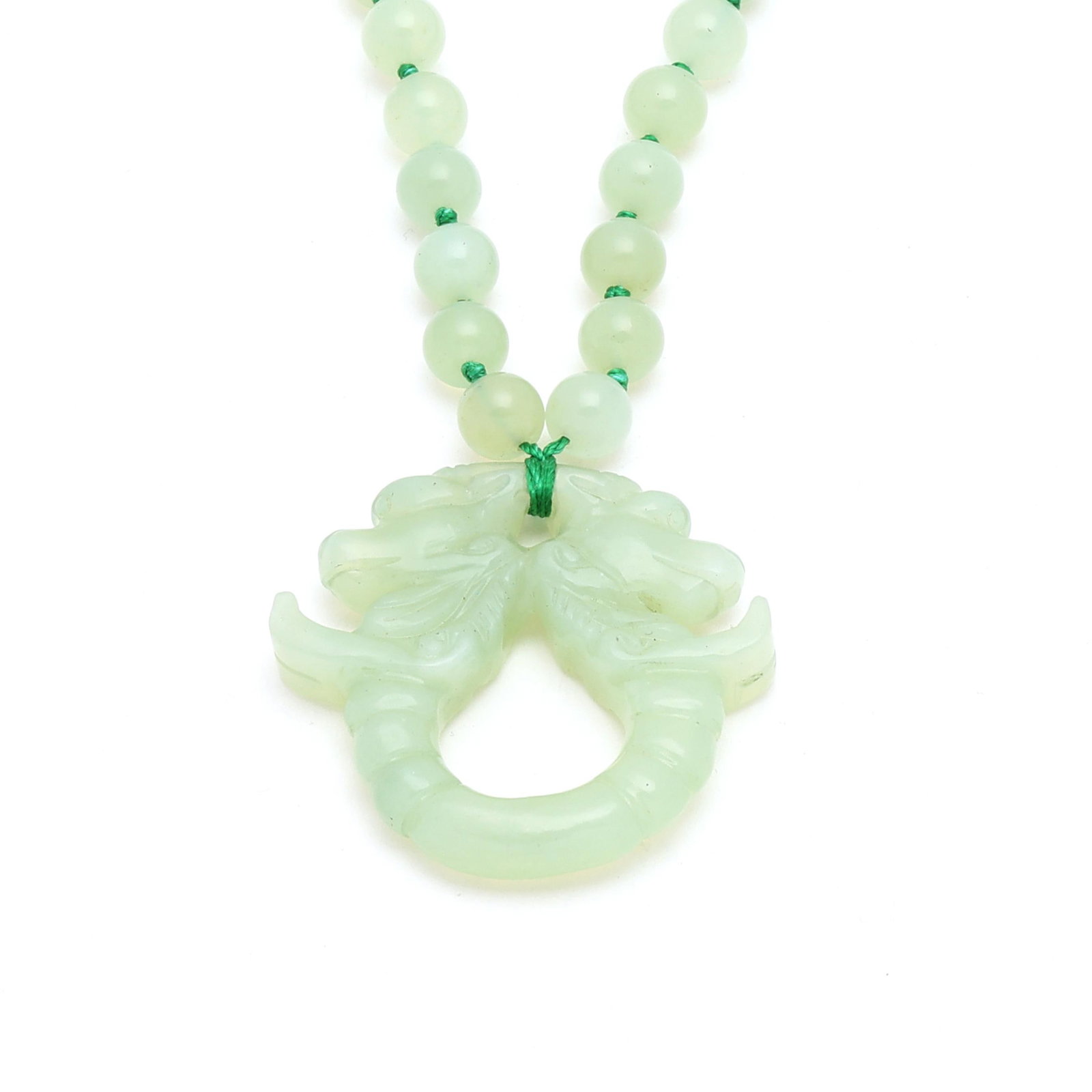 Serpentine Bead Necklace and Pendant: Serpentine Bead Necklace and Pendant strung knotted with round serpentine beads (10mm) and suspending a carved serpentine pendant in a double-headed dragon motif. Necklace 28 in.; Pendant 2 3/16 in.