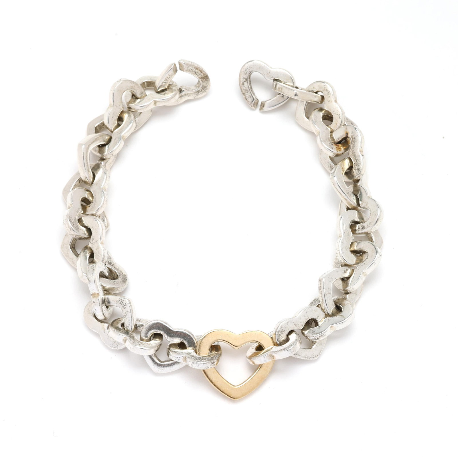 Gold and Silver Heart Link Bracelet, Tiffany & Co.: Gold and Silver Heart Link Bracelet, Tiffany & Co. 2001, the silver heart links with a central gold heart link, completed with an integrated clasp, signed, dated, and stamped 925 750 Italy. 9/16 x