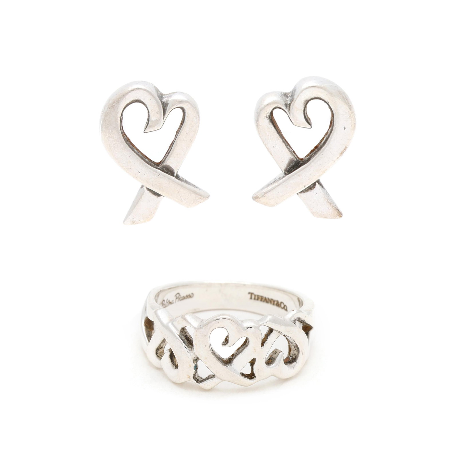 Silver Heart Ribbon Ring and Earrings, Paloma Picasso for Tiffany & Co.: Silver Heart Ribbon Ring and Earrings, Paloma Picasso for Tiffany & Co. to include: a silver ring with openwork heart ribbon motif, signed and stamped 925 (9mm; ring size 6); and a pair of silver