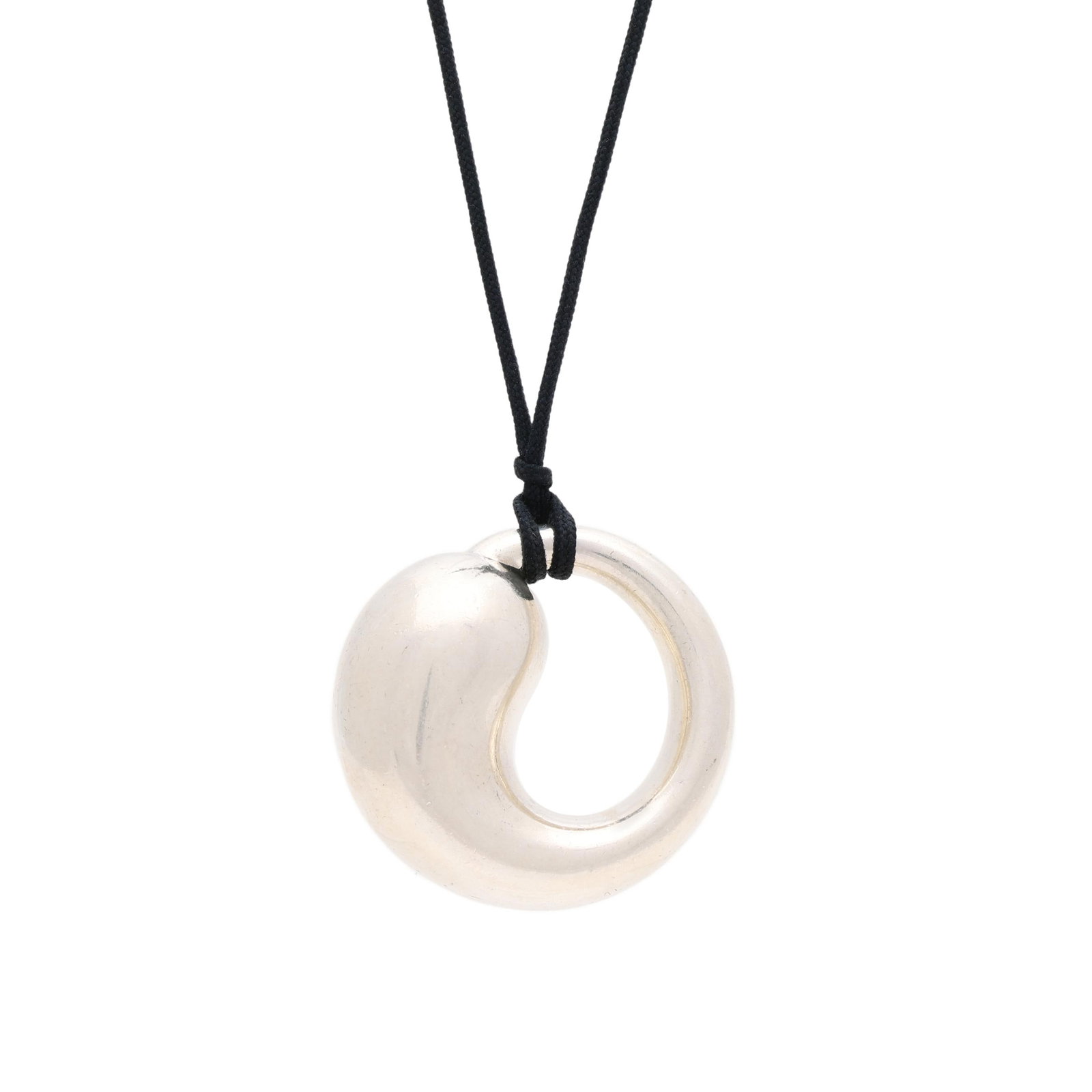 Silver Eternal Circle Pendant, Elsa Peretti for Tiffany & Co.: Silver Eternal Circle Pendant, Elsa Peretti for Tiffany & Co. the silver pendant in a sculptural circle design, suspended from a black cord, signed, stamped 925 Spain, and with a maker's mark.