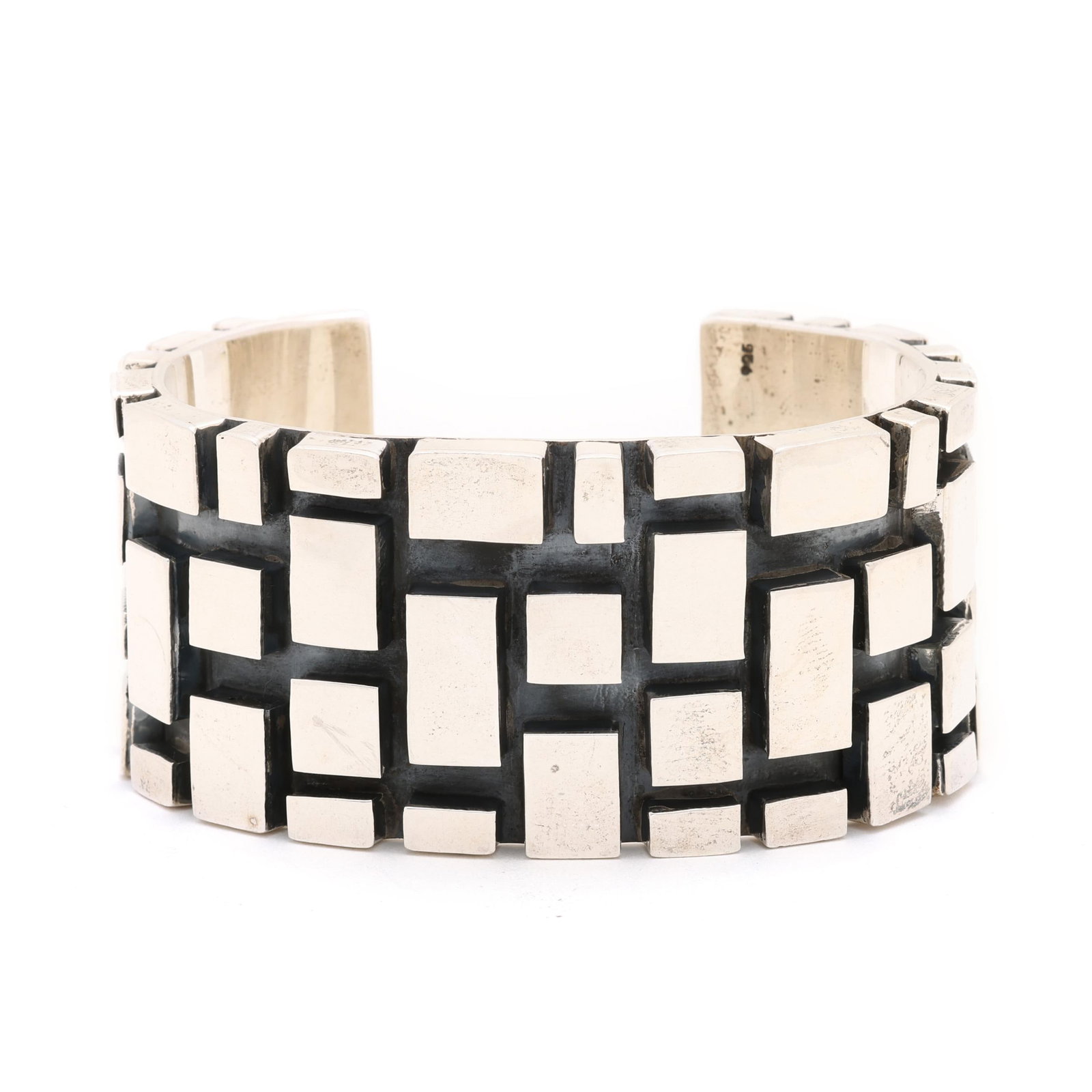 Silver Geometric Motif Cuff Bracelet: Silver Geometric Motif Cuff Bracelet the cuff bracelet in a raised, geometric motif, stamped 925 and with a maker's mark. 1 3/8 x 5 5/8 in. with 1.25 in. opening 3.46 troy oz. Additional