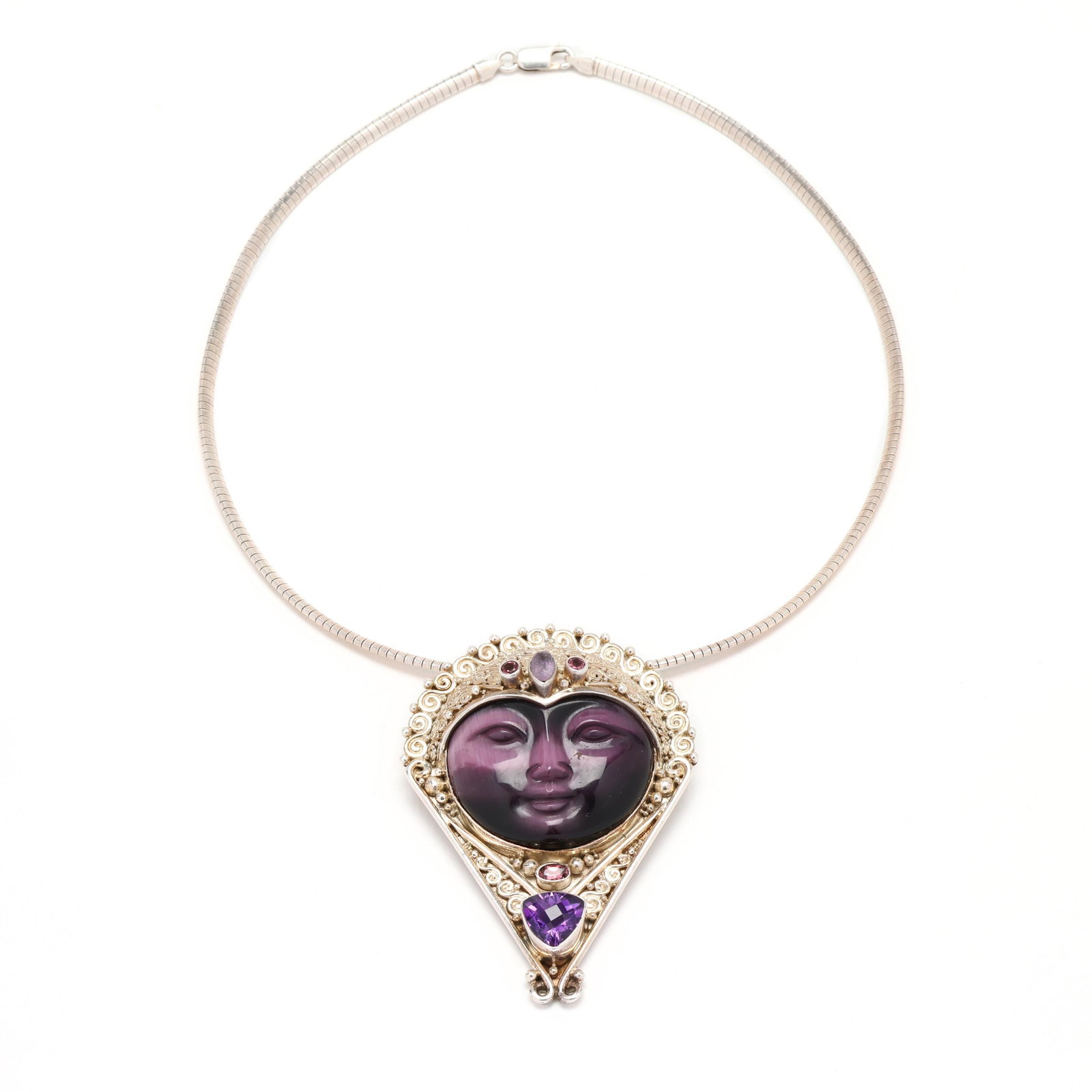 Silver and Gem-Set Purple Fiber Optic Goddess Figural Pendant, Sajen: Silver and Gem-Set Purple Fiber Optic Goddess Figural Pendant, Sajen the pendant / brooch centered on a carved purple fiber optic stone in the image of a face within an intricate silver setting,