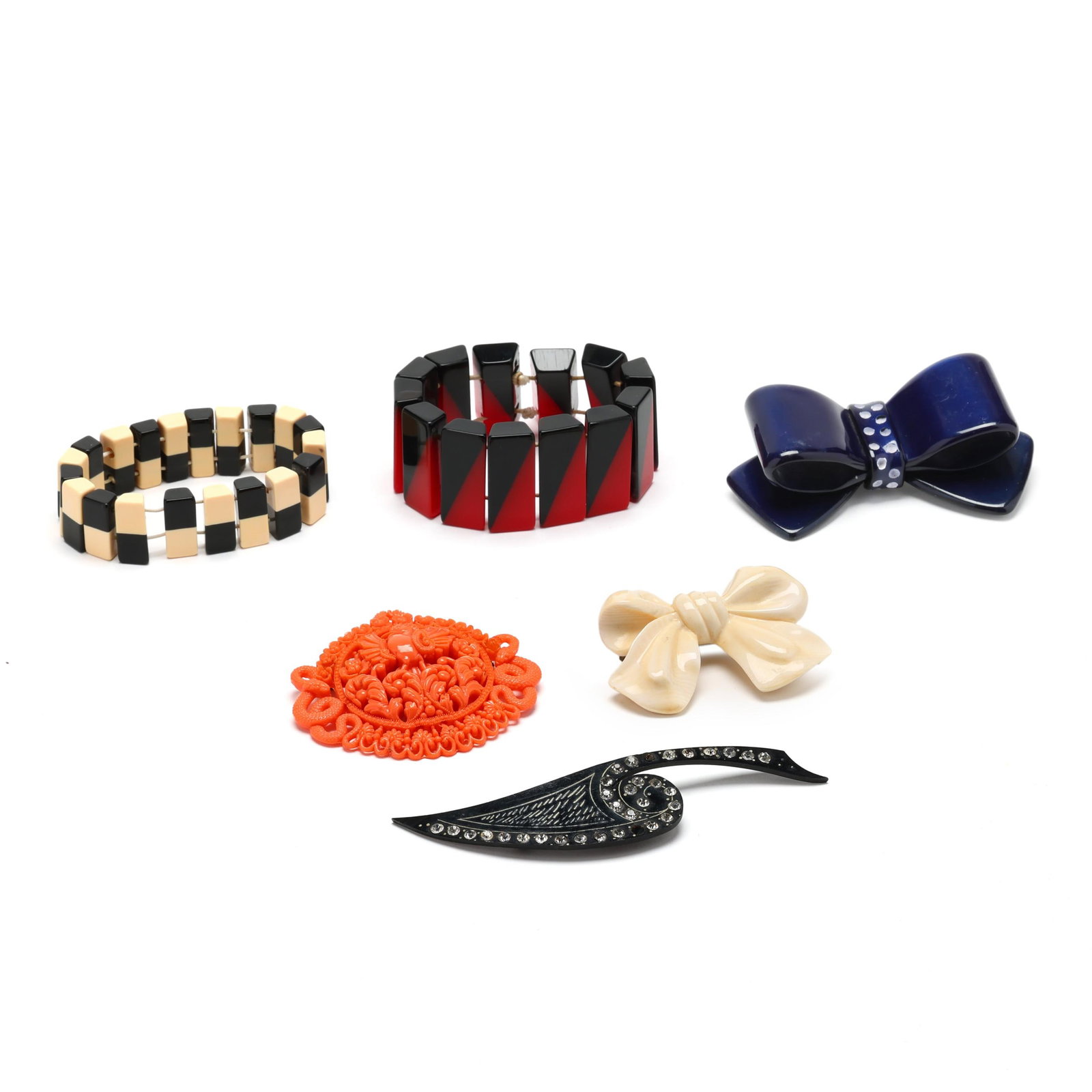 Group of Composition Jewelry: Group of Composition Jewelry to include: a blue brooch in the form of a bow with white polka dots, completed with a pin stem (2 x 3 7/8 in.); a white brooch in the form of a bow, completed with a lock