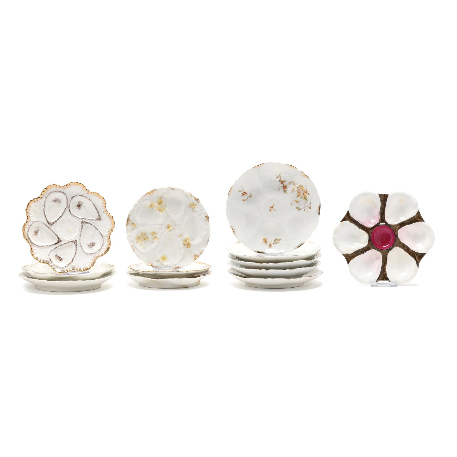 A Collection of Twelve Continental Porcelain Oyster Plates: A Collection of Twelve Continental Porcelain Oyster Plates Germany and France, late 19th-early 20th century, including five Limoges examples with gilt and floral decoration, comprising (2) with gilt a
