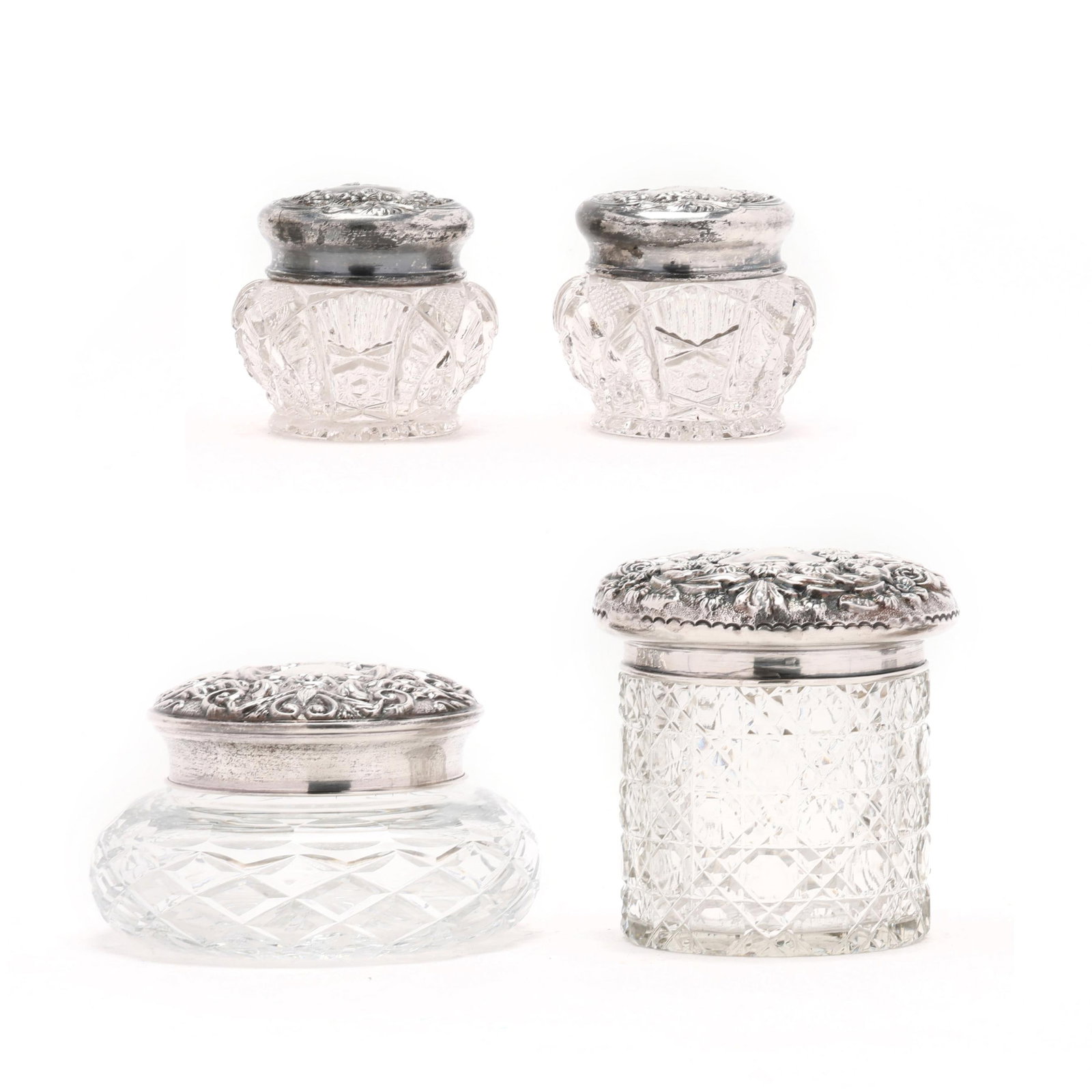 Four Silver Mounted Glass Dressing Boxes: Four Silver Mounted Glass Dressing Boxes the tallest, an Edwardian Silver mounted crystal box, mark of George Nathan & Ridley Hayes, Chester (1901), featuring floral repousse and shield cartouche, (4 
