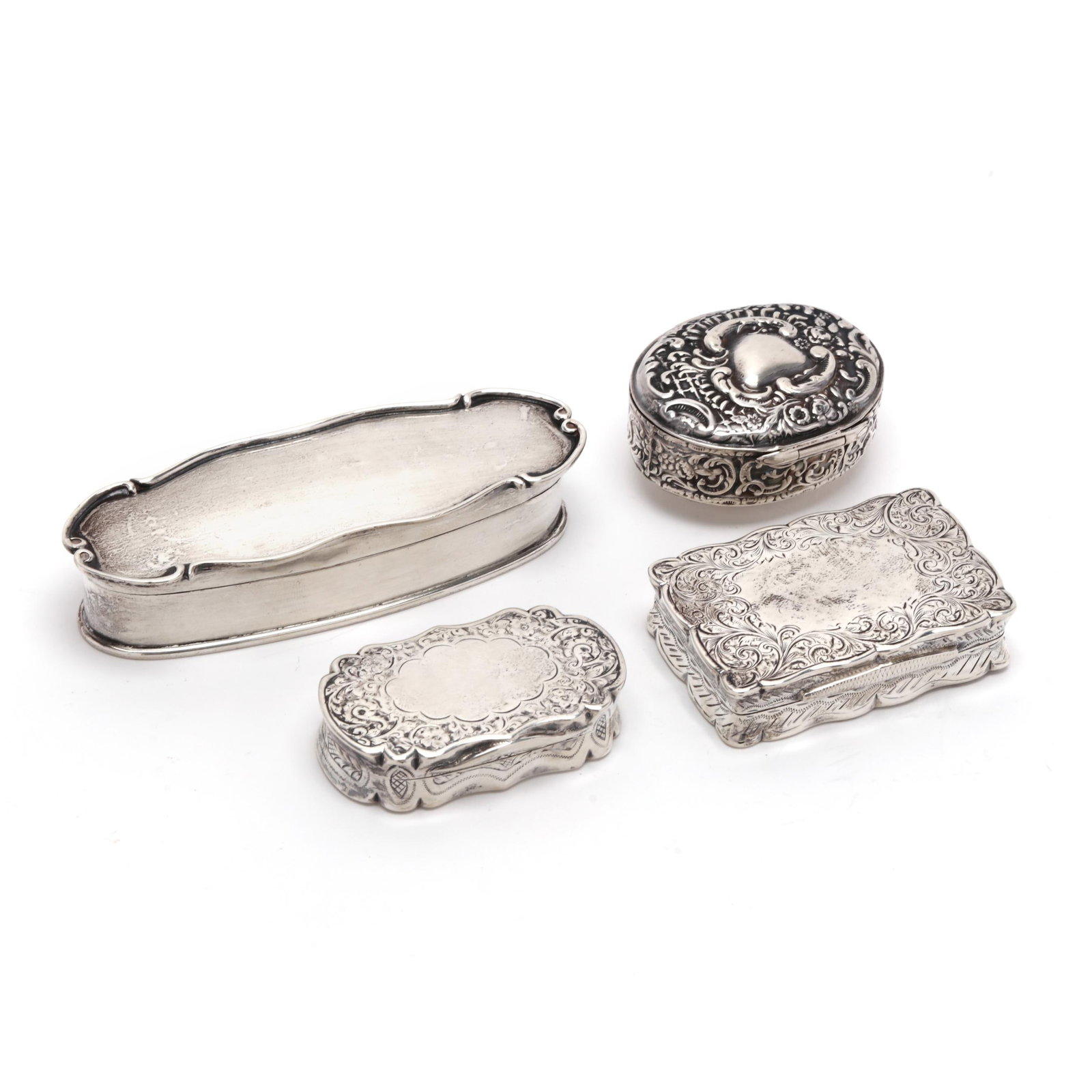 Four English Silver Pill or Patch Boxes: Four English Silver Pill or Patch Boxes including an oval repousse hinge lidded box with mark of Dowler & Sons, Birmingham (1899); a rectangular box with engraved floral borders and conforming shaped 