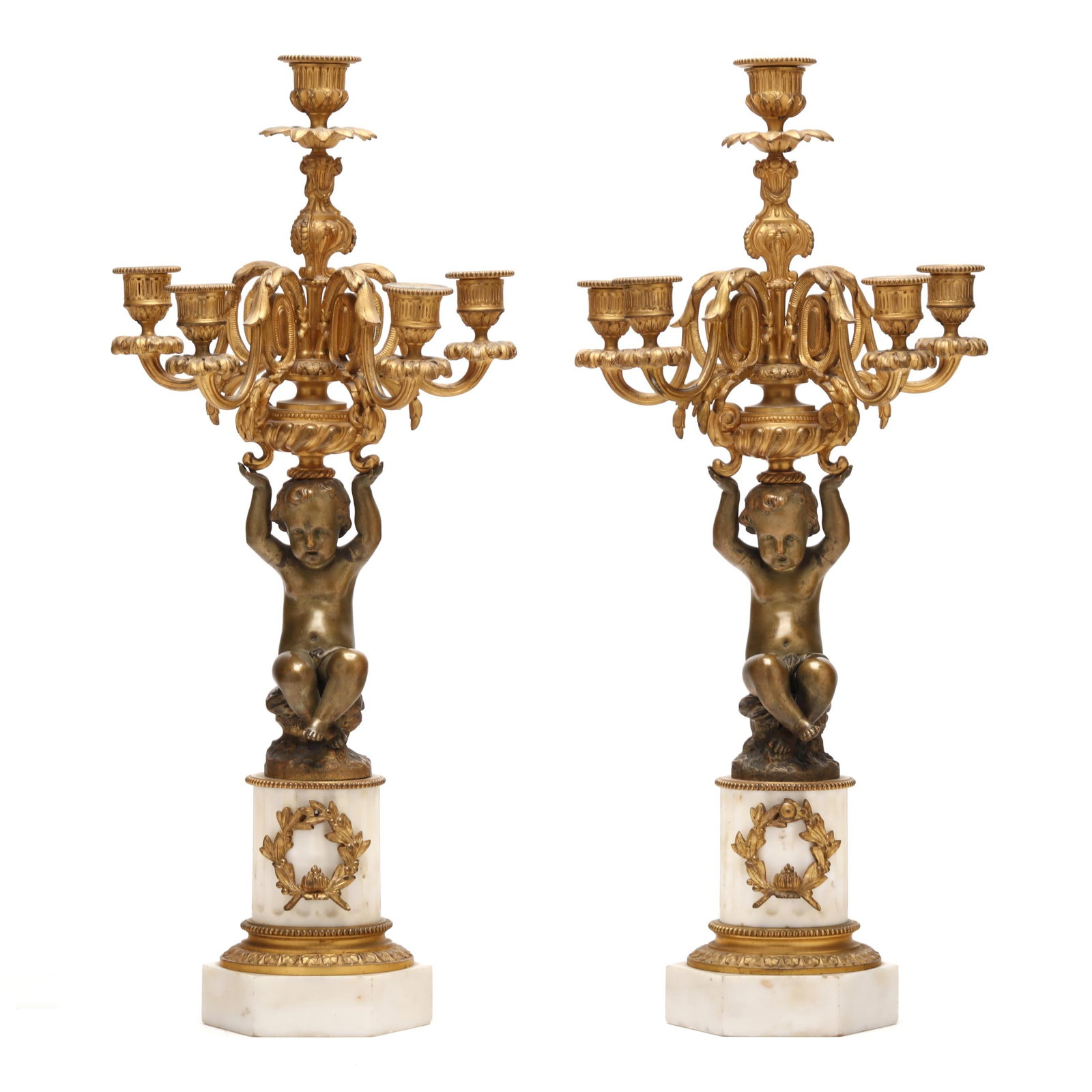 A Pair of Napoleon III Bronze and Marble Putti Five-Light Candelabra: A Pair of Napoleon III Bronze and Marble Putti Five-Light Candelabra circa 1880s, comprising a well-cast patinated bronze putto seated upon a rockwork terrace, supporting a five-light ormolu