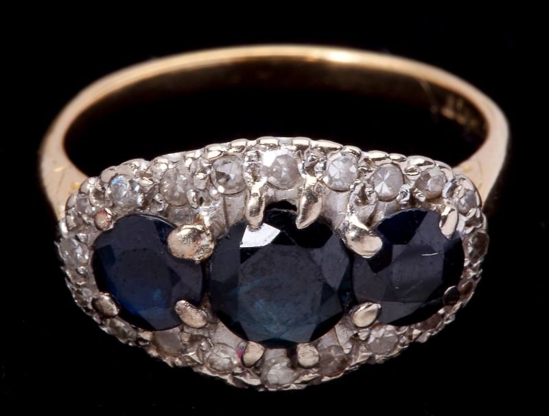 Vintage Sapphire and Diamond Ring: Vintage Sapphire and Diamond Ringset to the front with (3) round faceted sapphires each weighing approximately .75 carat prong set and framed by (19) single cut round diamonds (approximately .19 total
