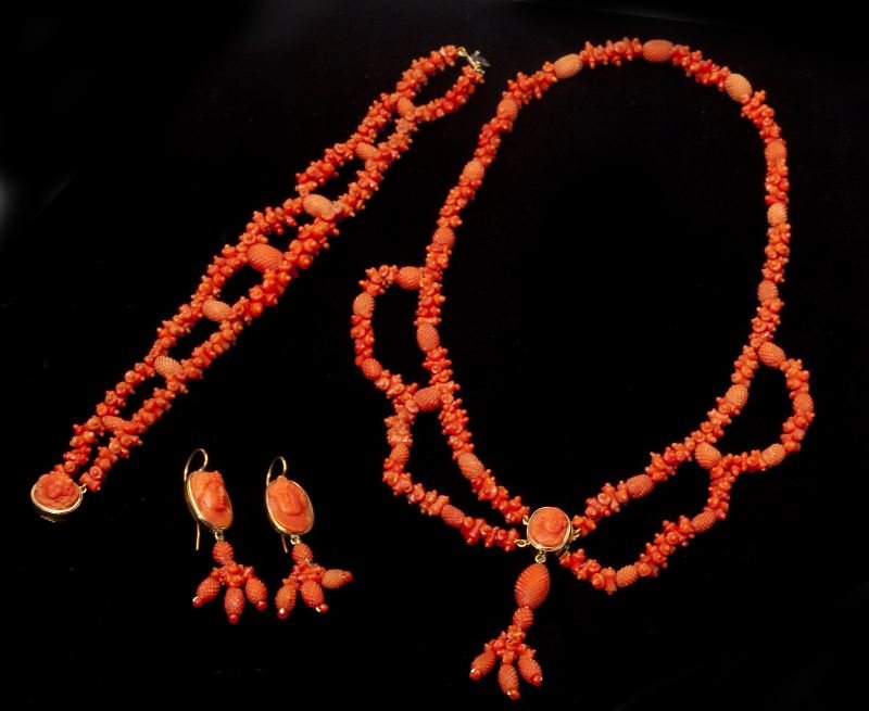 Victorian Carved Red Coral Suite: Victorian Carved Red Coral Suitethe necklace comprised of carved coral and set to the front with a cameo within a gold bezel mount suspending a drop pendant (LOA 17 in.); bracelet comprised of a doubl