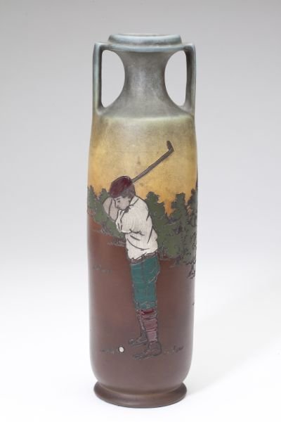 Dickens Ware/Weller Golf Theme Vase, E.L. Pickens: Dickens Ware/Weller Golf Theme Vase, E.L. Pickenscirca 1900, Weller Second Line, of amphora form with incised and polychrome decoration on brown and blue field depicting a young golfer, with impressed