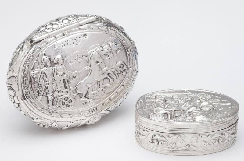 Two Continental Silver Snuff Boxes: Two Continental Silver Snuff Boxes the first an example of Hanau silver with pseudo marks and mark for the London importer Samuel Boyce Landeck, of oval form with chariot scene to hinged cover, portra