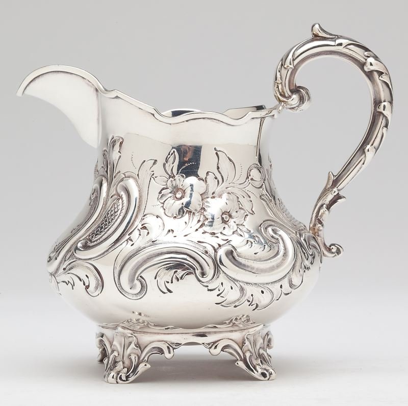 Victorian Silver Cream Jug: Victorian Silver Cream JugLondon (1851) hallmarks, Richard Poulden's sponsor's mark, with repousse and chased decoration in the Rococo taste, armorial engraving to front cartouche, raised on four appl