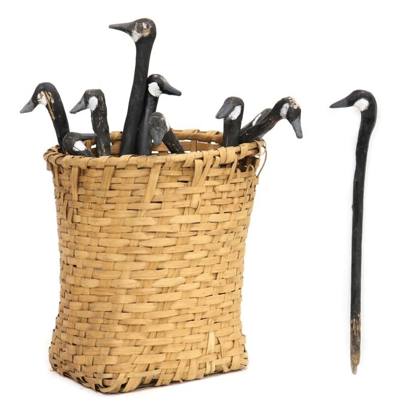 Ten Goose Head Stick Field Decoys: Ten Goose Head Stick Field Decoyscarved and painted, from Bob Timberlake Rig, made by Charlie Myers, in an antique splint feather basket.Geese 25 - 36 in.; Basket 23 in.Selected objects from The Bob T
