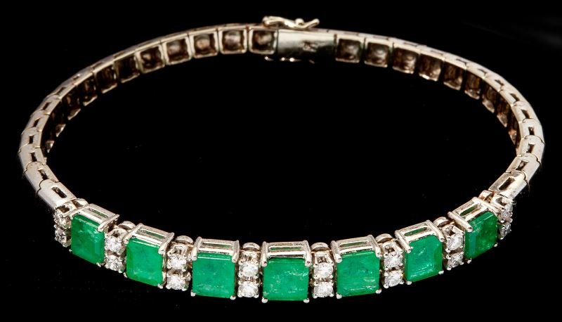Gold Emerald and Diamond Bracelet: Gold Emerald and Diamond Bracelet designed as a line bracelet and with a center station set with (7) square cut emeralds (5.50 x 4.80 x 3.01mm) alternating with (2) full cut round diamonds (2.00mm); t