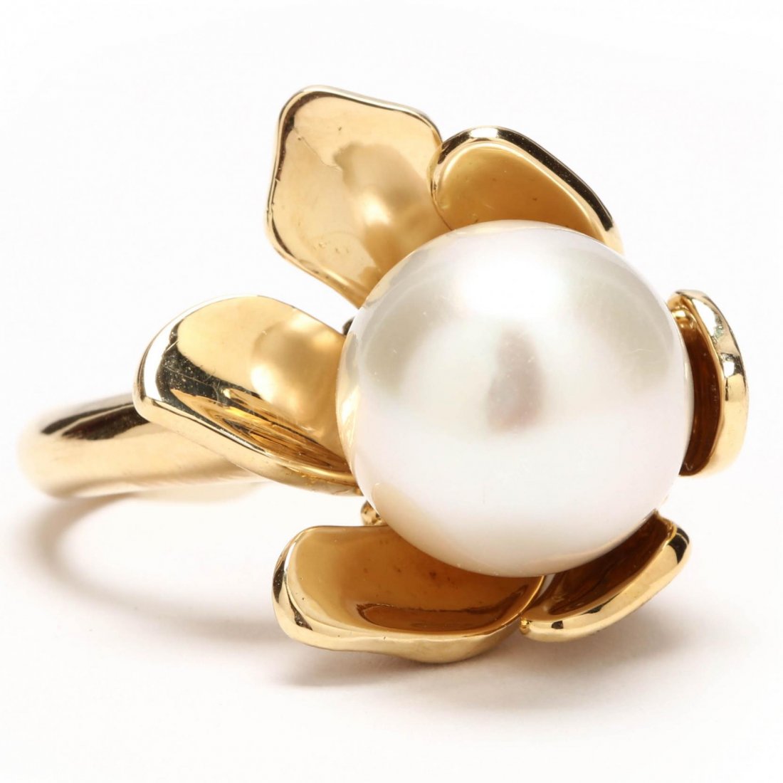 18KT, Pearl, and Diamond Ring, Julius Cohen: in a bold floral design featuring one South Sea white tear drop shaped pearl (14.25 x 18mm) centered in textured and high polish yellow gold "petals" and accented with (15) single cut round diamonds b