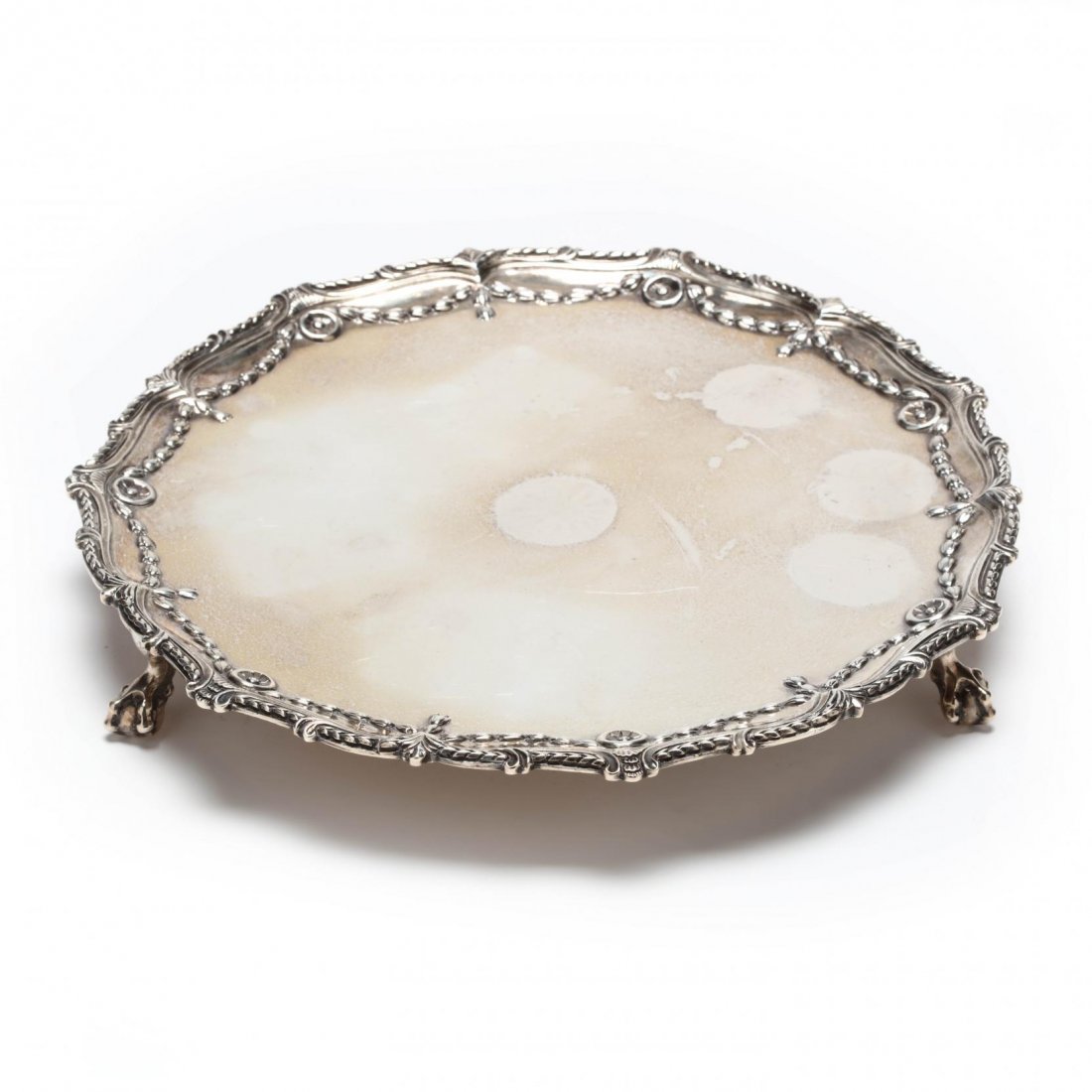 Georgian Silver Salver: with "RR" sponsor's mark, London (1774) hallmarks, neoclassical garland and rosette motif to shaped rim, raised on three ball and claw feet. 9 7/8 in diameter. 19.85 troy oz.