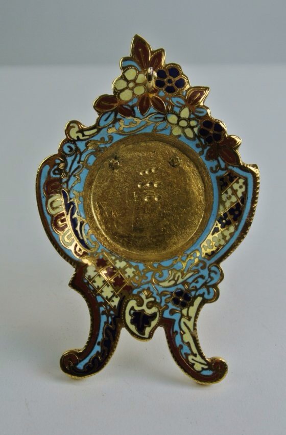 DORE BRONZE AND CHAMPLAVE ENAMEL POCKET WATCH HOLDER: 19th century gilt bronze and Champleve enamel , pocket watch holder . 2,5" h. Estimate $100-150
