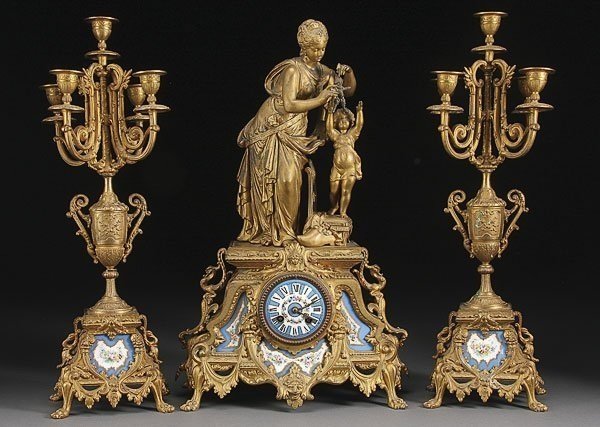 19TH CENTURY SEVRES CLOCK GARNITURE: A 19th century gilt metal and SEVRES porcelain clock garniture. Clock measures 24" h . Estimate $1,500-1,800