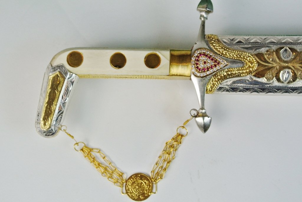 SILVER & GOLD SWORD INSET WITH DIAMONDS & RUBIES: A Royal Saudi Arabian sword , silver inlaid with gold, diamonds and rubies, measures 41" long. Estimate $4.000-5.000