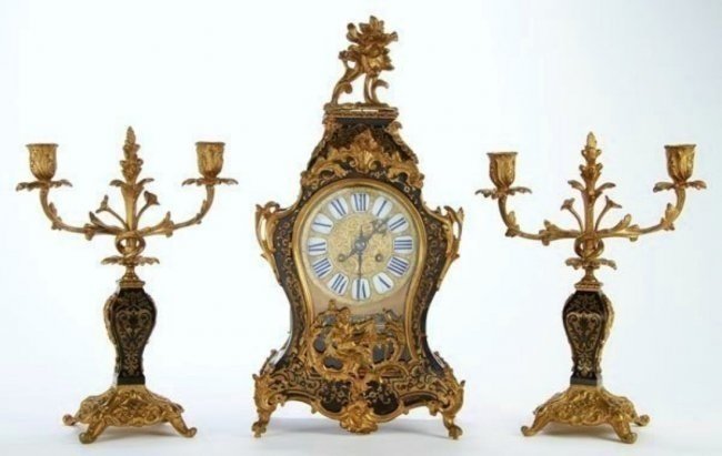 19TH CENTURY FRENCH BOULLE CLOCK SET: A French Louis XV style Boulle clock garniture,late 19th century.The corseted case with foliate bronze mounts and scrolled brass inlay, with two matching scroll arm candelabra Clock 18.25", candelabra