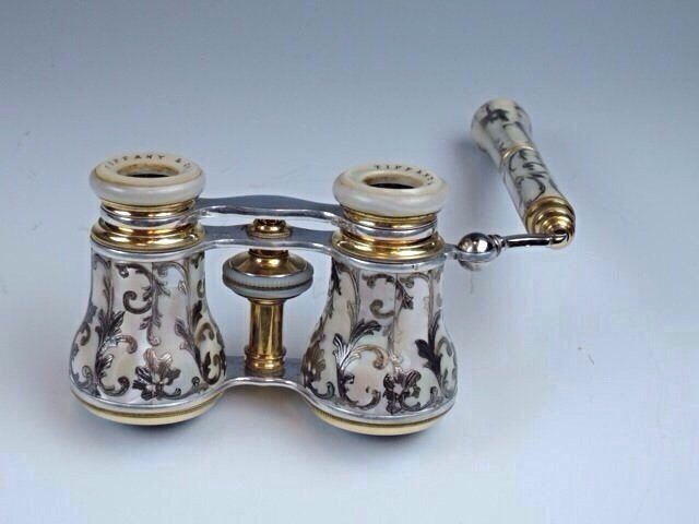 PAIR OF OPERA GLASSES BY "TIFFANY &CO": Wonderful pair of opera glasses by "Tiffany & Co" with mother of pearl veneer inlaid and silver &gold scrolling foliage, signed. Estimate $800-$900