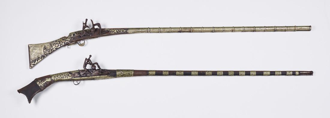 Two 19C Persian Middle Eastern Flintlock Muskets: Two 19th or early 20th century Arabian, Indo-Persian, or Arabic muskets or camel guns have overlaid brass decoration and one has bone inlay. As-found condition with rusting barrels. One has a separate