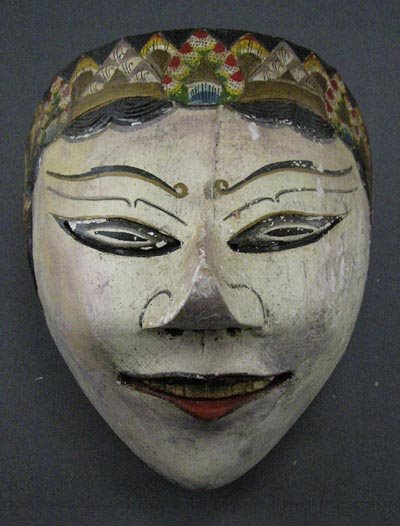 Indonesian 1940s Painted & Carved Wooden Mask.: Painted and carved wooden Indonesian mask probably from the 1940s or earlier. The mask depicts a flared-nose woman in a multi-colored head-dress. It retains most of the original finish although there