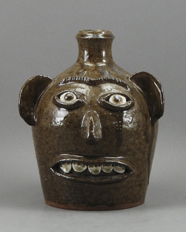 Stoneware Folk Art Charles Lisk, Vale N.C Face Jug: Glazed Stoneware Charles Lisk Face Jug. The jug is in good condition. Signed "Charles Lisk, Vale, N.C." Measures 8" high with a 6 ½" diameter.
