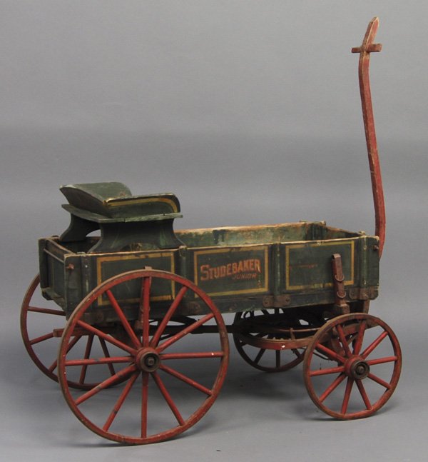 Studebaker Junior 19C Painted Child's Wood Wagon: Studebaker Junior 19C Painted Child's Wagon. The Studebaker Junior painted child's wagon has the original green paint with gold striping and a red painted base and spoke wheels. It's marked on three s