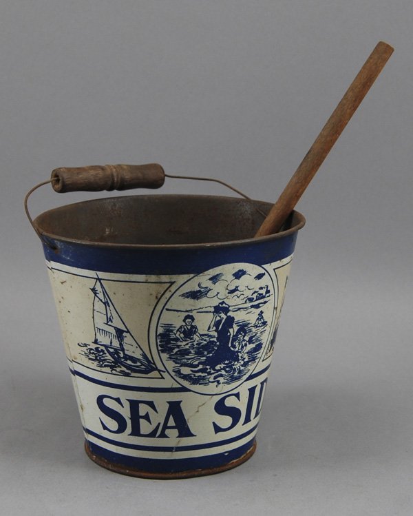 Tin Litho Seaside 1930s Toy Sand Pail & Shovel: Tin Lithograph Seaside 1930's Sand Pail. The sand pail has a lithograph scene of women and children at the seaside and in a speed boat as well as a sailboat. Includes wooden handle shovel that was fou