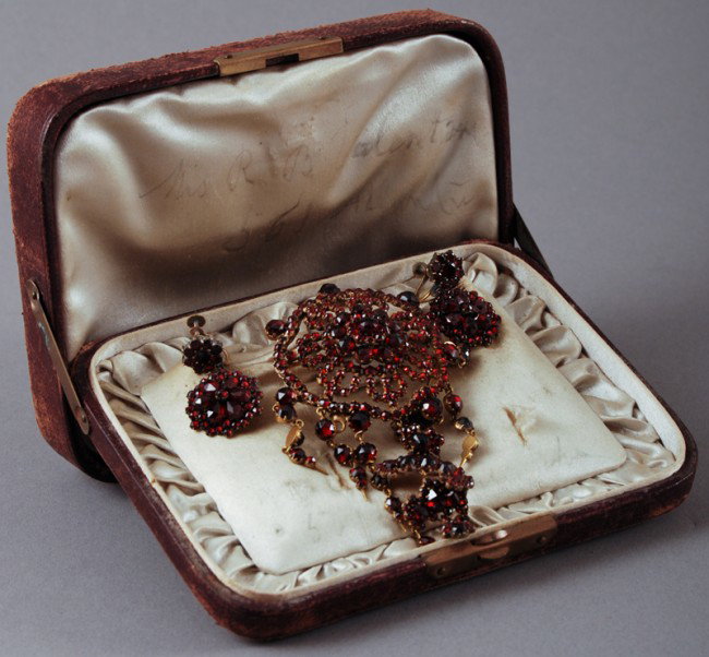 Ornate Edwardian Garnet Brooch and Earrings: Edwardian era round Garnet brooch and earrings. The screw backs are marked 10K but the set is Gold filled or "Garnet Gold". In good condition. The brooch measures 3 1/2" long, 2' wide. Original worn b