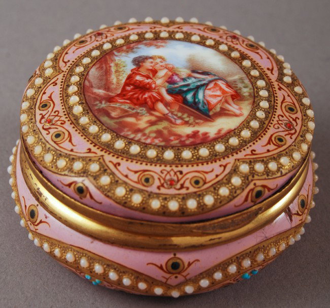 French 19C Enamel Round Box with Lovers: French 19th C Jeweled and Enamel Box. The 19th C French pink enameled box has applied jewel decorations covering the box and a center portrait of two lovers in a forest. The round hinged box does have