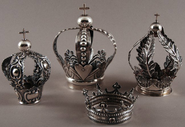 4 Spanish Colonial Coin Silver Santos Crowns: A collection of four antique coin silver Santos or Madonna crowns. Three measure 5 1/2" to 4 1/2" high and are of similar form and topped with crosses, the middle size one is hallmarked with an uniden