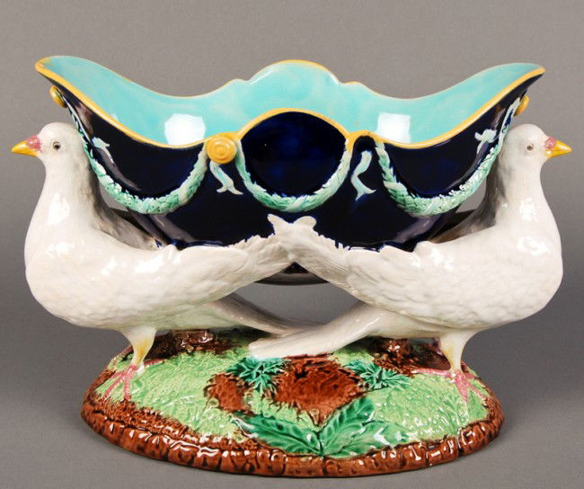 George Jones 19C Majolica Dove Centerpiece: George Jones 19C Majolica Dove Centerpiece. The majolica double dove centerpiece has an oval blue royal bowl, with garland decoration flanked with two white doves, which are mounted on an oval natural