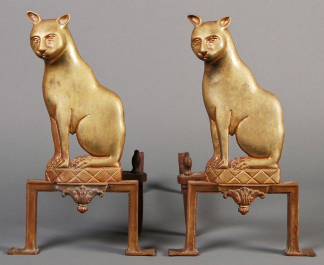Pair of Egyptian Revival 19C Brass Cat Andirons: A pair of brass Egyptian Revival cat andirons, late 19th or early 20th century. The iron fire dogs are marked Puritan. In good condition. Measure 14" high, 8 1/4" wide.