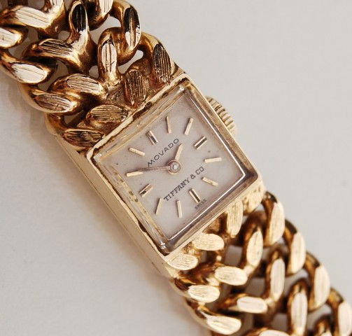 Tiffany Movado 14K Gold Bracelet Ladys Wristwatch: Tiffany Movado 14 karat yellow gold ladies wristwatch. The classic watch has a heavy link band and is signed on the dial Movado, Tiffany & Co., Swiss. The watch is running at this time. The band is ma