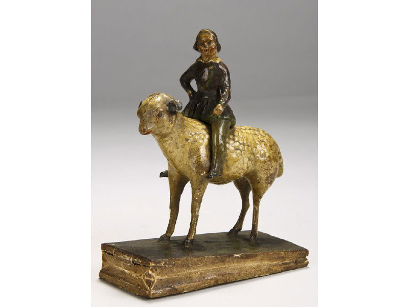 Papier Mache 1855 Girl on Lamb Squeak Toy: Early 19th Century Paper Mache Girl on Lamb Squeak Toy. The early bellows type papier-mâché girl on lamb squeak toy is in good overall condition. There is a hairline crack in the head of the lamb an