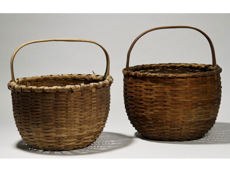 Two 19C Signed D.C.T. Round Handled 15" Baskets: Two Similar Round Handled Baskets. Both measure approximately 15 ½" high and 15" across. They are both carved with the owners initials in the handle "DCT". The lighter colored basket has some black r