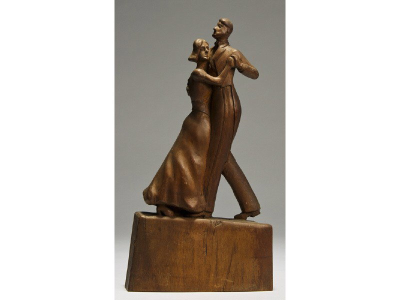 Folk Art Early 20C Carving of Dancing Man & Lady: American Folk Art Carving Early 20th Century Dancers. The carved wooden sculpture depicts a gentleman with a cut away tuxedo dancing with a young woman wearing a short sleeved gown and stands atop a c