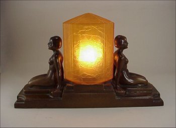 FRANKART Type 1920 Twin Nude Figure Lamp: FRANKART Type Twin Nude Figural Lamp from the 1920s. Finely cast symmetrical double seated nudes lamp base with eight sided amber art glass shade. Rich brown painted finish has small areas of loss. Th
