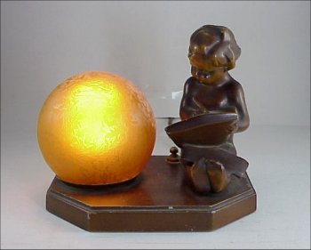 FRANKART type Figural 20s Art Deco Lamp: FRANKART Figural Art Deco Lamp. This 1920s Frankart-type painted figural metal lamp depicts a young child with swept back hair seated and writing in a notebook. The figure is next to a chipped ice, am