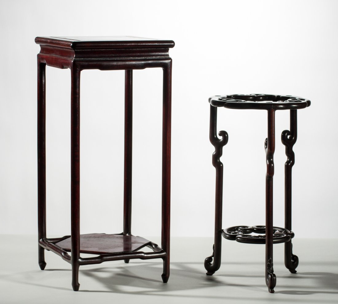 Two Carved Rosewood Chinese Small Display Stands: Two Chinese Small Carved Rosewood Display Stands. One with a shaped design with open work carving and medial shelf. The other stand is square with bottom shelf and round legs. The taller measures 21.5