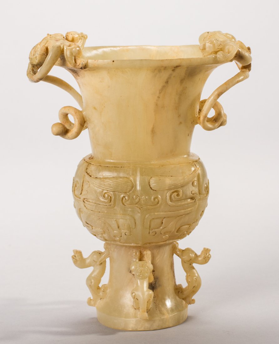 Chinese Carved Dragon Soapstone Footed Vase: Carved Chinese Soapstone Footed Vase. The vase is decorated with carved dragons. There is a hole in the bottom section of the vase, on the side. Appears to have been buried at one time. Measures 6.7 i