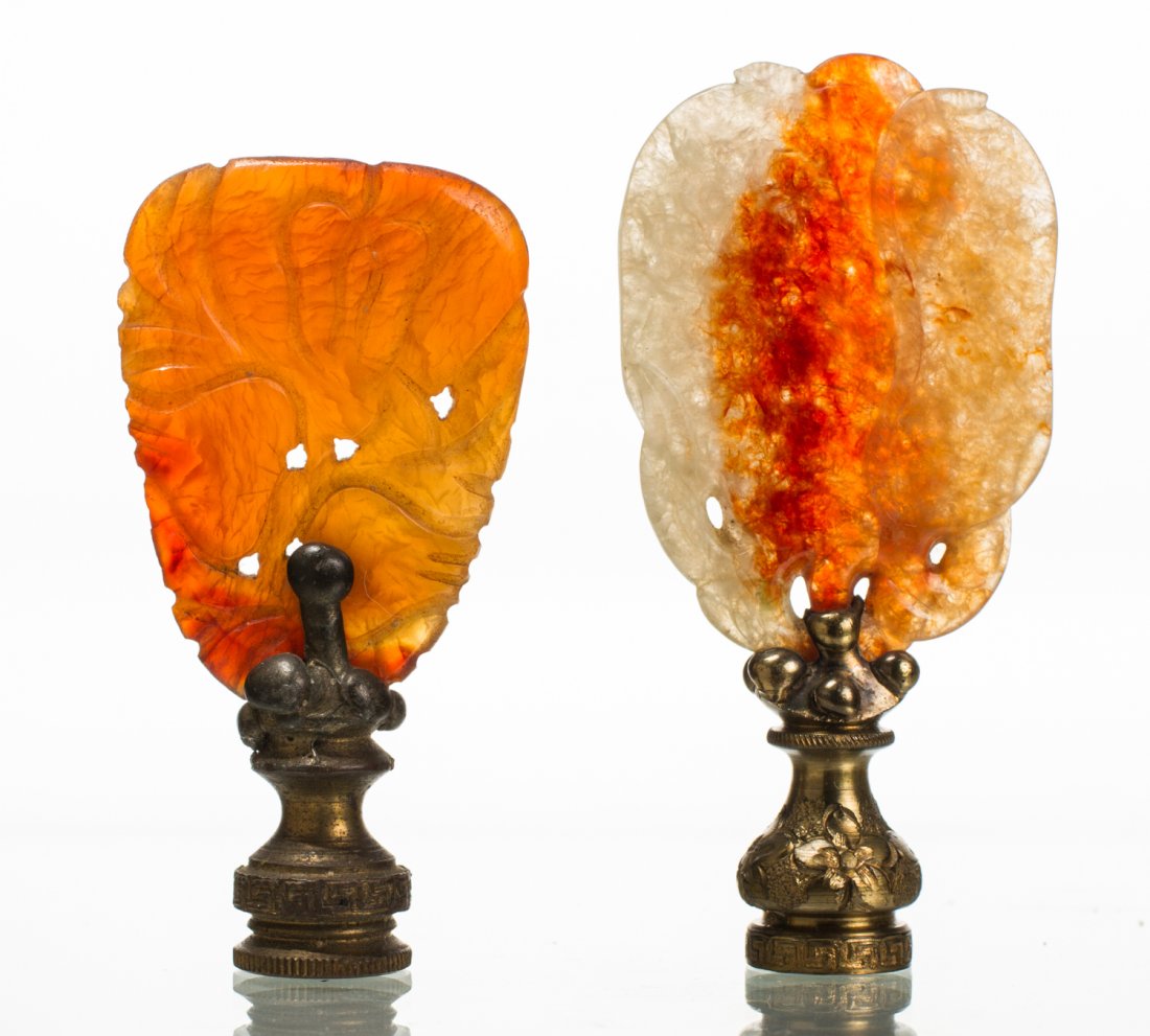 Two Chinese Carved Carnelian 1920's Lamp Finials: Two Chinese Art Deco 1920's Carved Carnelian Brass Lamp Finials. One of a solid carnelian color, the other ranges from light green to a red carnelian hue. Both in good condition. Measure 2.8 inches in