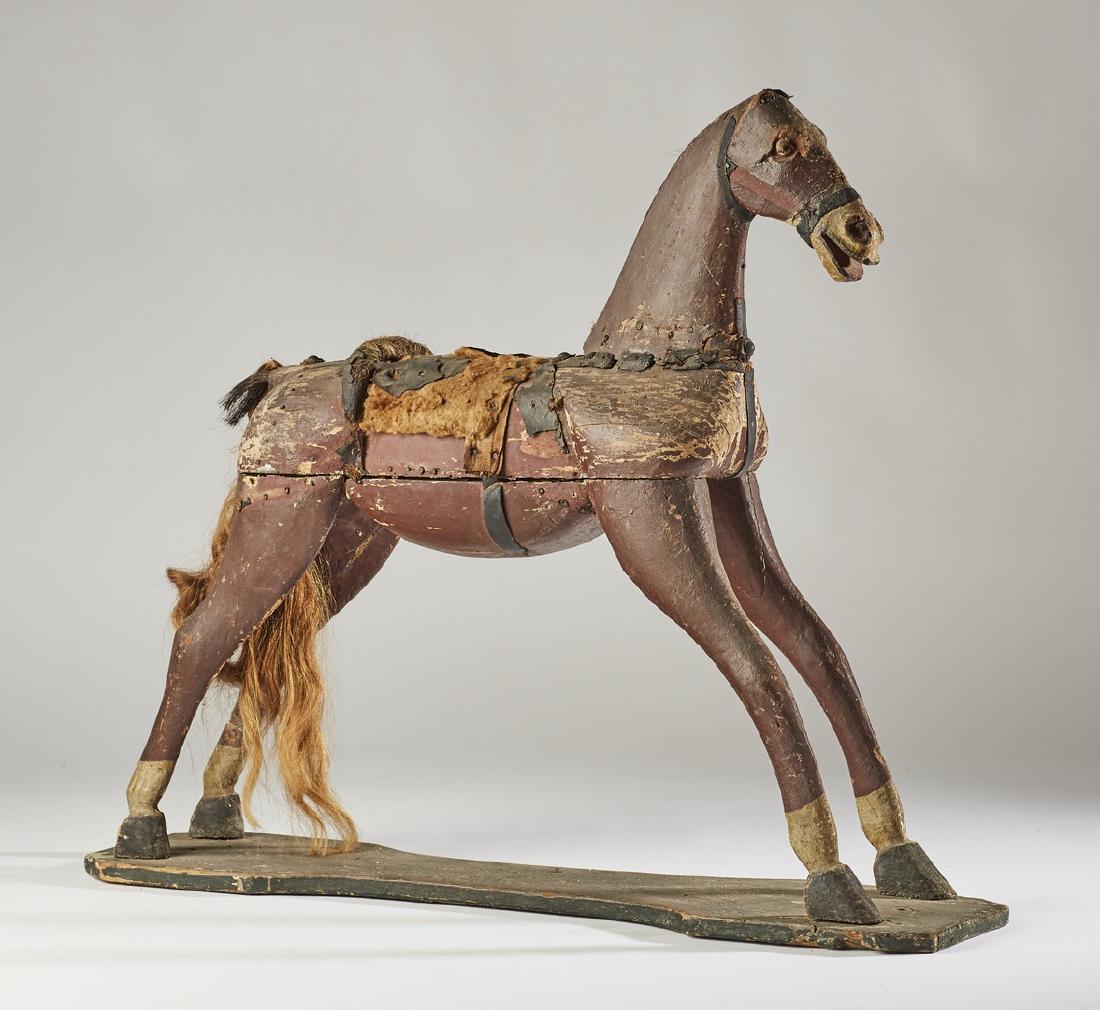 Old Carved 34 inch Wooden 19C Riding Horse Toy: Old Carved 34 inch Wooden 19C Riding Horse Toy. The old horse toy has a hand carved face and body with the some of the original paint. The saddle has loss. Most likely was on wheels at one time. One b