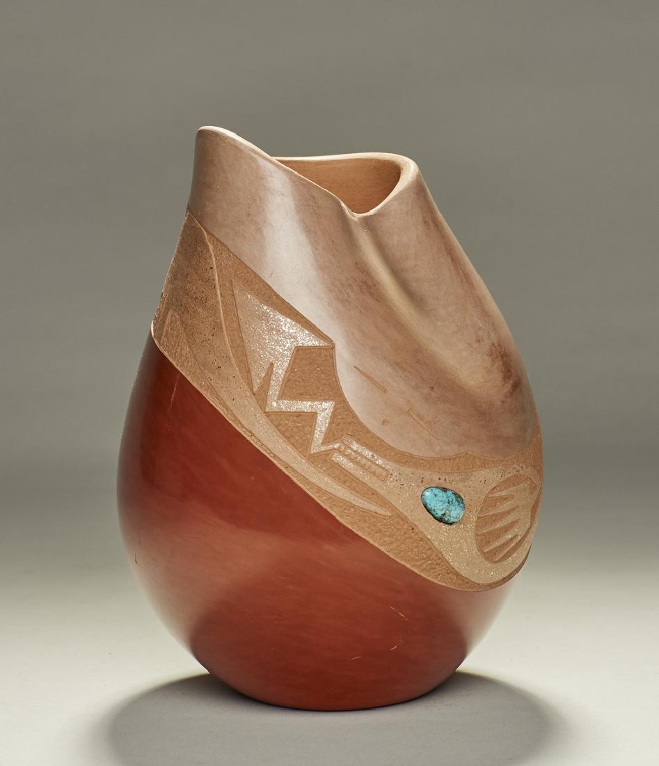 San Ildefonso Pueblo - R. Sanchez Turquoise Vase: Native American Indian San Ildefonso Russell Sanchez Turquoise Vase. The two color pottery vase is set with a turquoise and there is a serpent design around the body. In good condition. Signed Russell