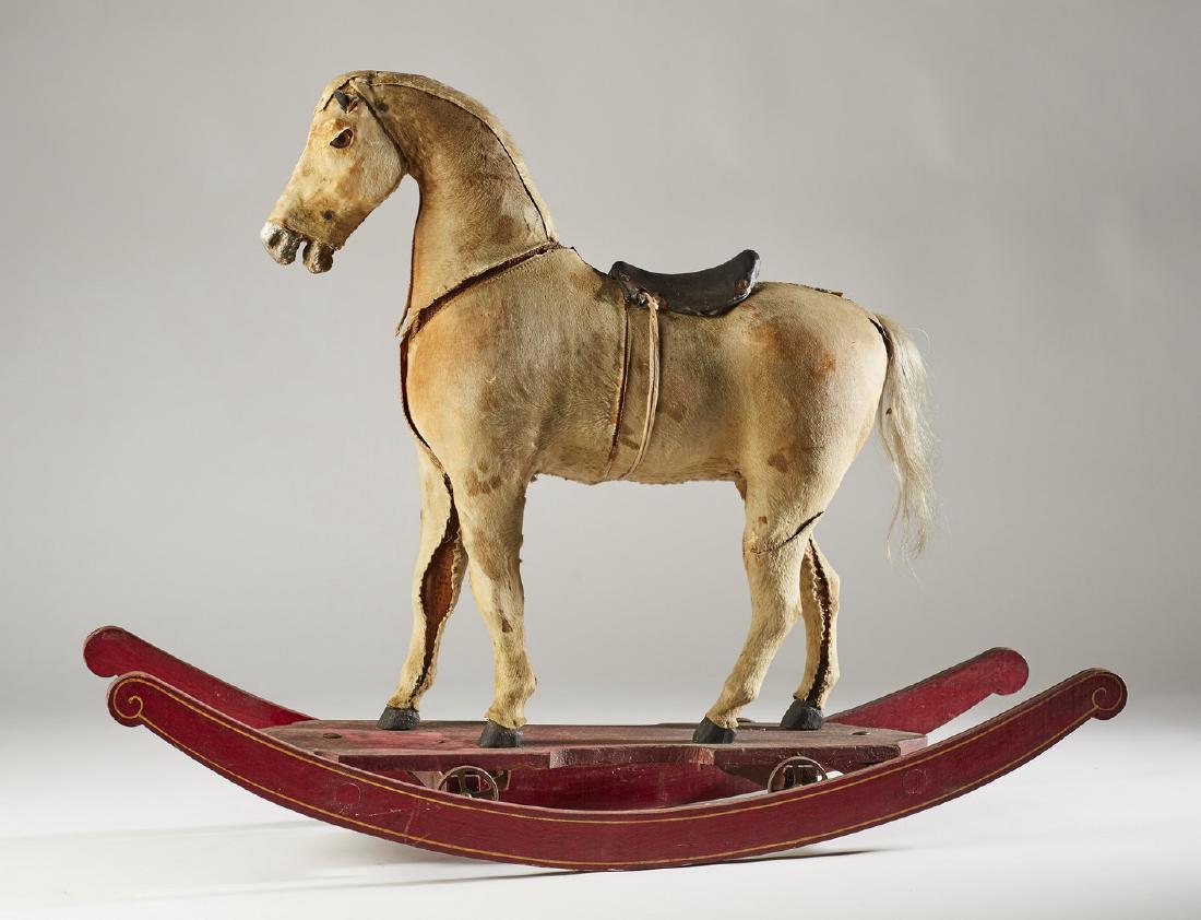 Old 19C Hide Covered Rocking Horse on Wheels Toy: Old 19C Hide Covered Wooden Rocking Horse on Wheels Toy. The 19th century cow hide covered horse has dried out over the years and is suffering some separation and loss of stitching mounted on a wheele